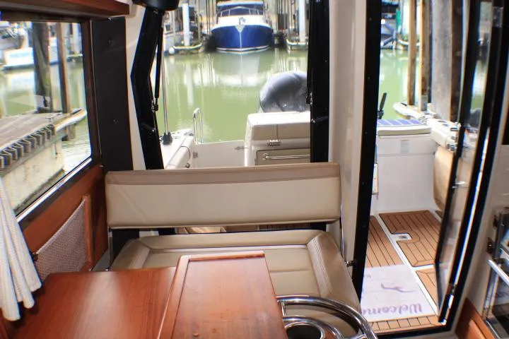 Slide: The Image of 2020 Ranger Tugs R-27 interior view with docked boats in background. - 61