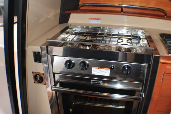 Slide: The Image of 2020 Ranger Tugs R-27 interior kitchen with stainless steel stove and oven. - 68