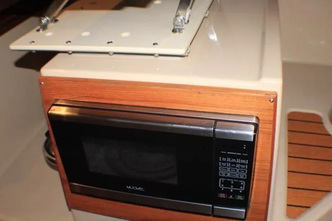 Slide: The Image of Microwave in 2020 Ranger Tugs R-27 boat interior, featuring wood paneling. - 70