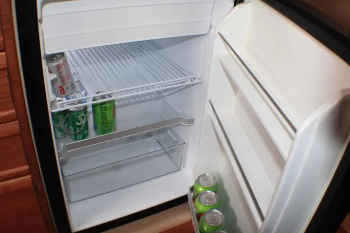 Slide: The Image of Compact refrigerator inside 2020 Ranger Tugs R-27, stocked with soda cans. - 72