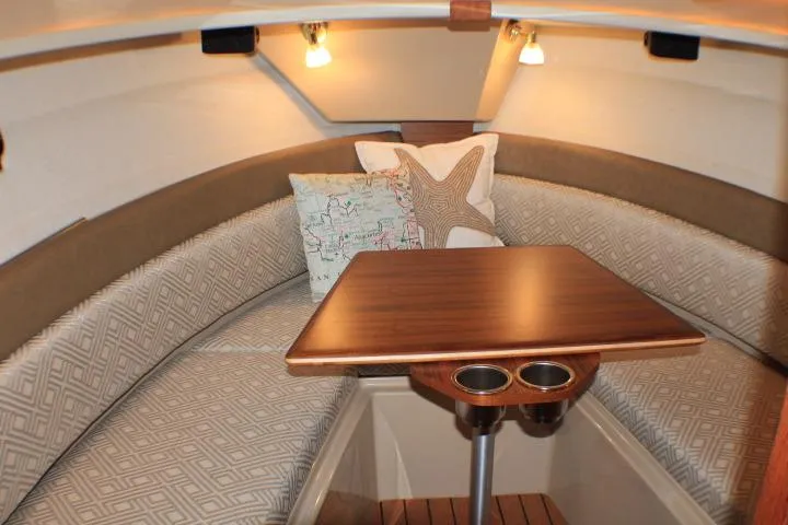 Slide: The Image of 2020 Ranger Tugs R-27 cabin interior with cozy seating and wooden table. - 73