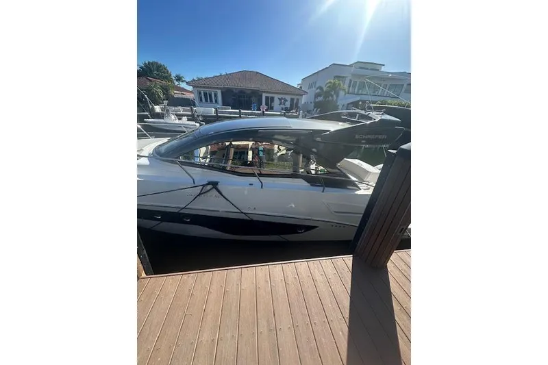 Slide: The Image of 2023 Schaefer 400 yacht docked under sunny skies near waterfront homes. - 50
