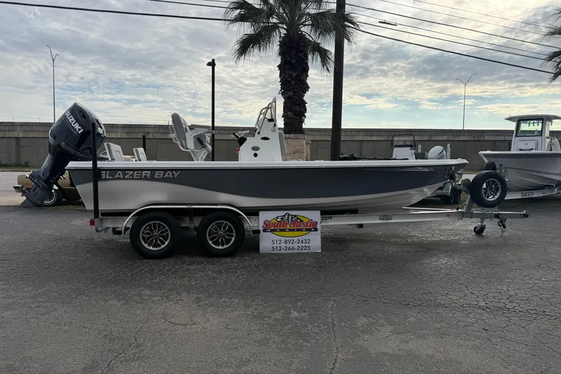 The Image of 2026 Blazer PureBay 2200 boat on trailer, parked outdoors near palm trees. - 0