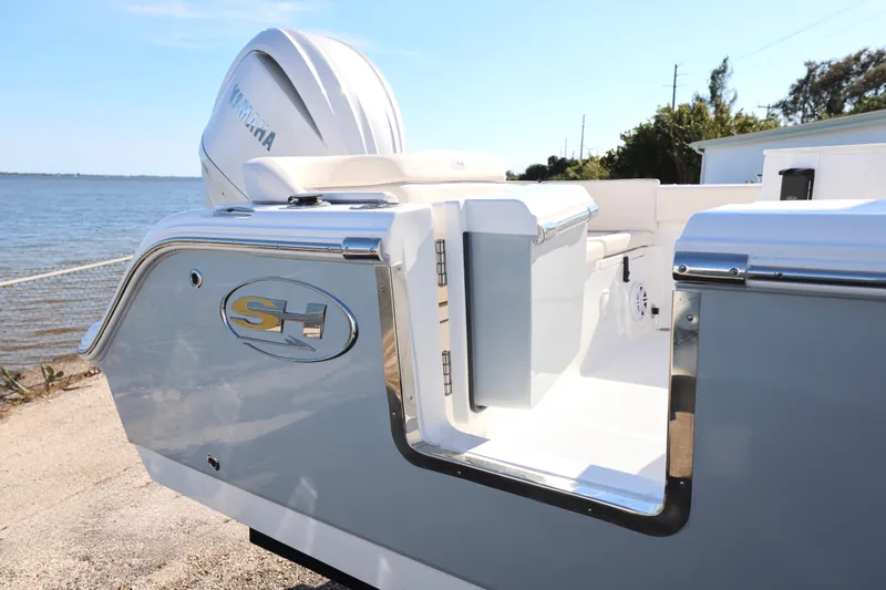 Slide: The Image of 2026 Sea Hunt Ultra 245 SE boat with Yamaha engine, docked by the water. - 16