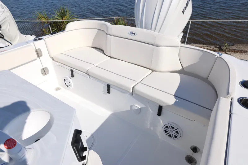 Slide: The Image of 2026 Sea Hunt Ultra 245 SE boat interior with white cushioned seating by the water. - 22