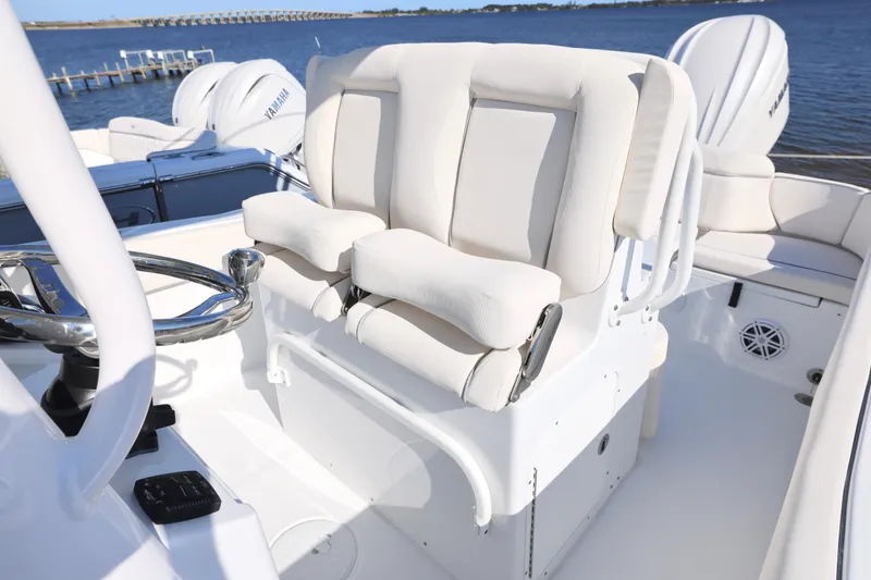 Slide: The Image of 2026 Sea Hunt Ultra 245 SE boat interior with steering wheel and cushioned seating. - 8