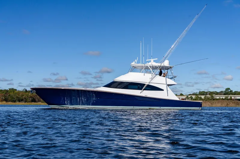 The Image of 2024 Viking 72 Convertible yacht cruising on open water under clear blue sky. - 0