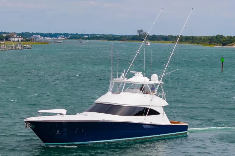 Slide: The Image of 2024 Viking 72 Convertible yacht cruising on a scenic waterway. - 10