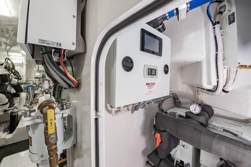 Slide: The Image of Engine room of 2024 Viking 72 Convertible yacht with control panels and wiring. - 113