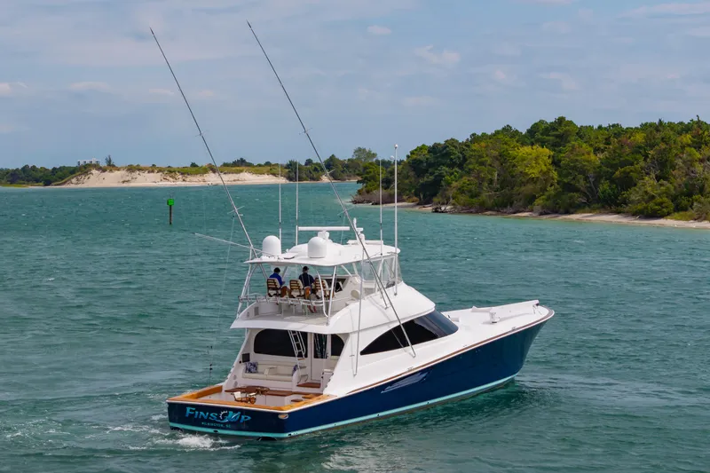 Slide: The Image of 2024 Viking 72 Convertible yacht cruising in scenic coastal waters. - 13