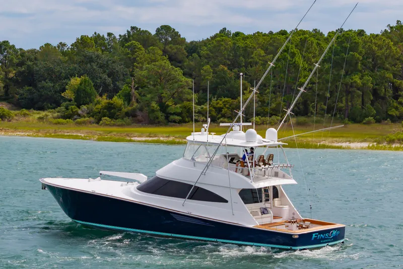 Slide: The Image of 2024 Viking 72 Convertible yacht cruising on a scenic waterway. - 14