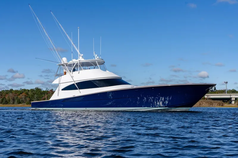 Slide: The Image of 2024 Viking 72 Convertible yacht on calm water under clear blue sky. - 2