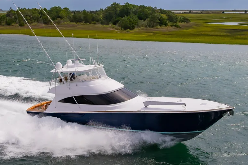 Slide: The Image of 2024 Viking 72 Convertible yacht cruising on a scenic waterway. - 20