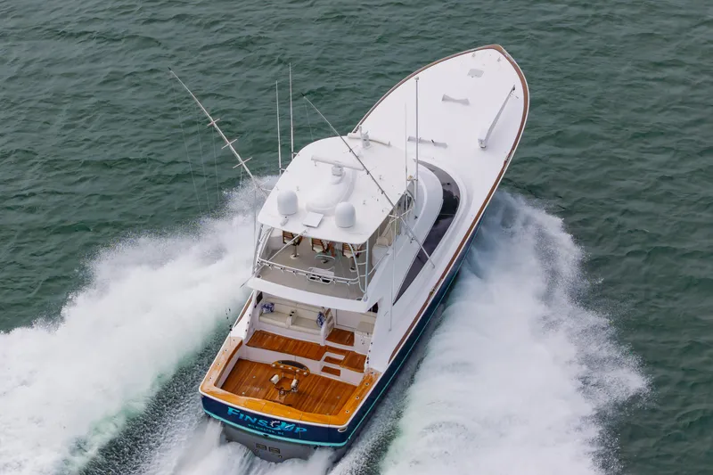 Slide: The Image of 2024 Viking 72 Convertible yacht cruising swiftly on open water. - 24