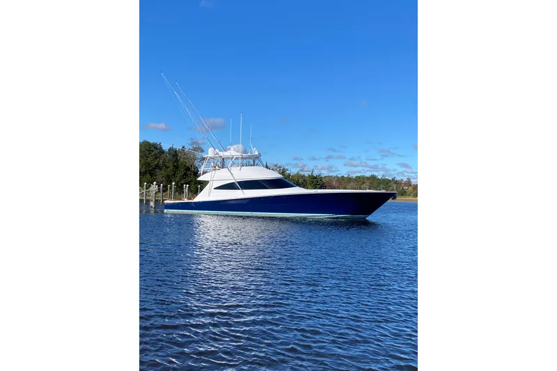 Slide: The Image of 2024 Viking 72 Convertible yacht on calm water under clear blue sky. - 3