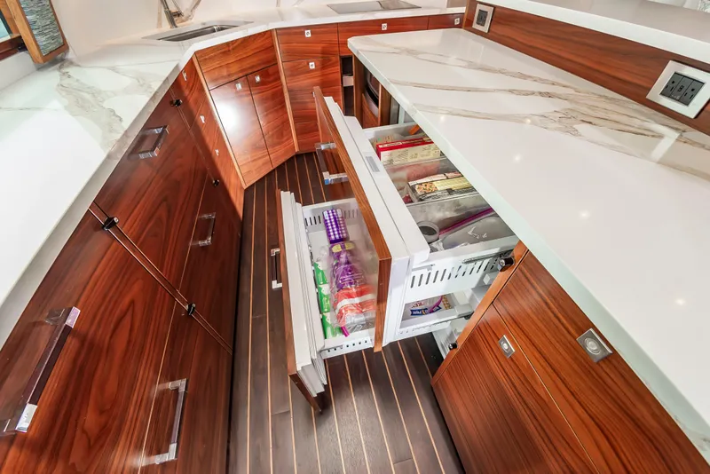 Slide: The Image of Luxurious kitchen interior of 2024 Viking 72 Convertible yacht with sleek cabinetry and open drawers. - 57