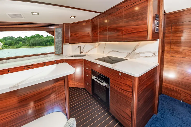 Slide: The Image of Luxurious kitchen interior of 2024 Viking 72 Convertible yacht with wood cabinetry and modern appliances. - 59