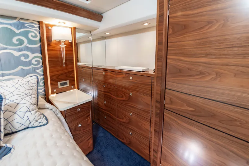 Slide: The Image of Luxurious 2024 Viking 72 Convertible yacht interior with elegant wood cabinetry and plush bedding. - 71