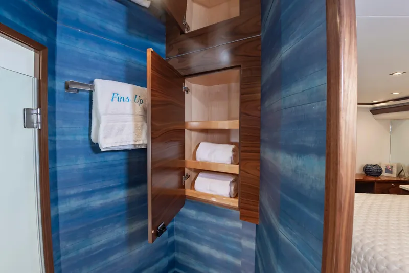 Slide: The Image of Luxurious bathroom interior of 2024 Viking 72 Convertible yacht with blue walls and wooden cabinet. - 75