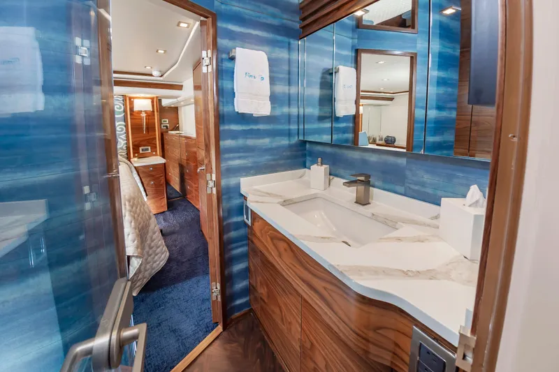 Slide: The Image of Luxurious bathroom interior of 2024 Viking 72 Convertible yacht with modern fixtures and blue accents. - 77