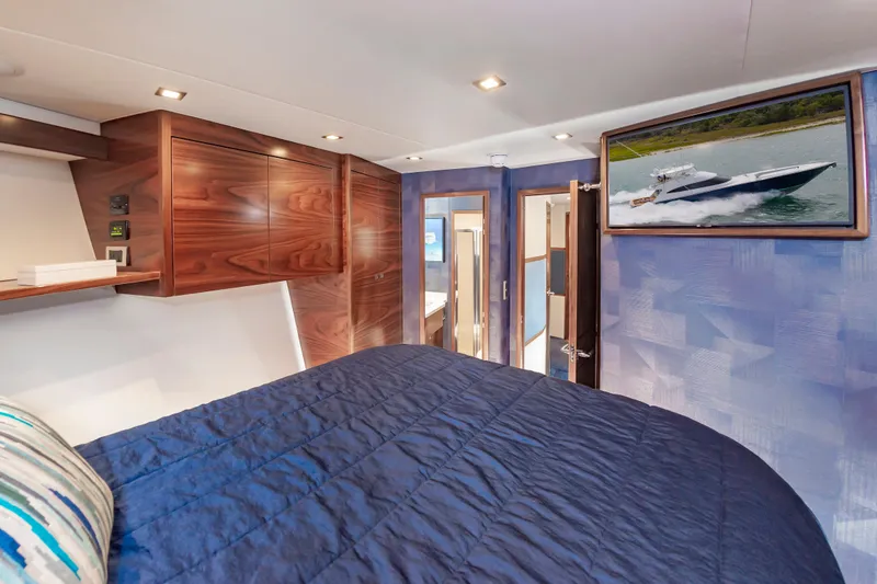 Slide: The Image of Luxurious bedroom interior of 2024 Viking 72 Convertible yacht with modern wood finishes. - 84