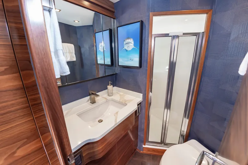 Slide: The Image of Luxurious bathroom in 2024 Viking 72 Convertible yacht with modern fixtures and elegant wood accents. - 86
