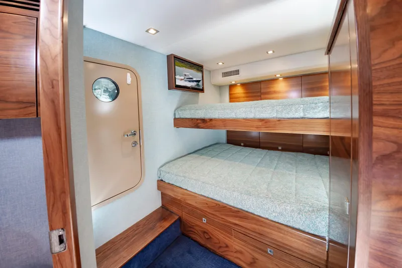 Slide: The Image of 2024 Viking 72 Convertible yacht cabin with wooden bunk beds and modern decor. - 90
