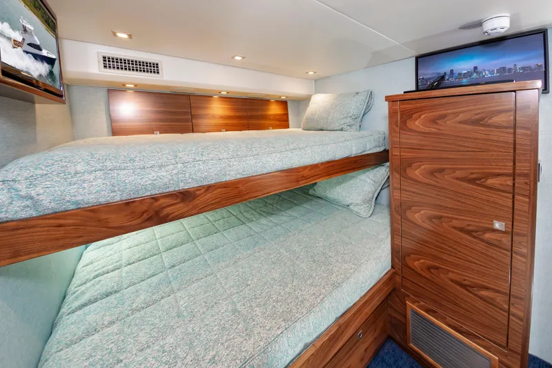 Slide: The Image of 2024 Viking 72 Convertible yacht interior with wooden bunk beds and modern decor. - 91