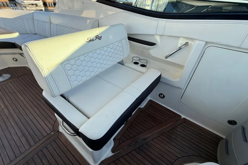 Slide: The Image of 2019 Sea Ray 320 Sundancer interior with white seating and wood flooring. - 10