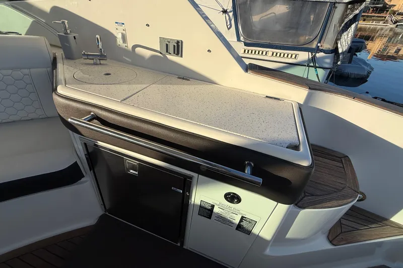 Slide: The Image of 2019 Sea Ray 320 Sundancer boat interior with kitchenette and seating area. - 12
