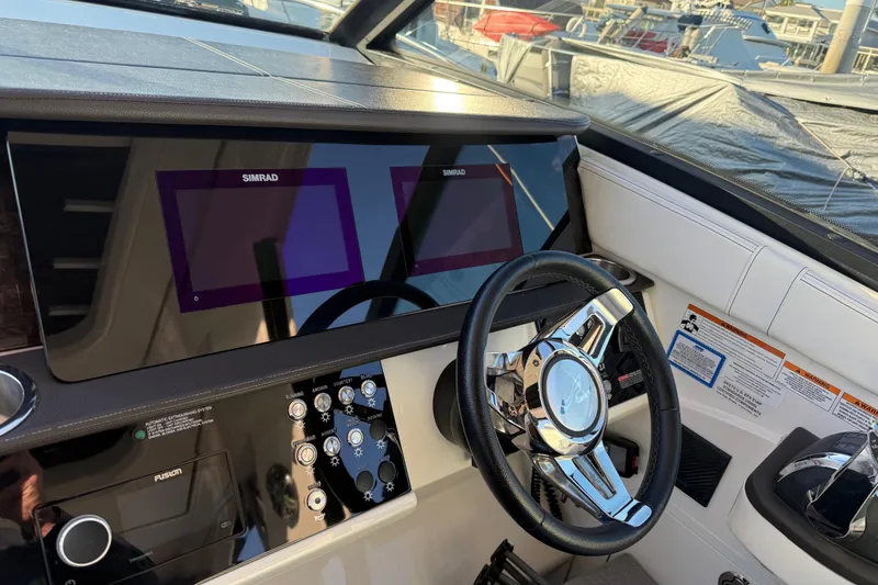 Slide: The Image of 2019 Sea Ray 320 Sundancer helm with Simrad displays and modern steering wheel. - 14