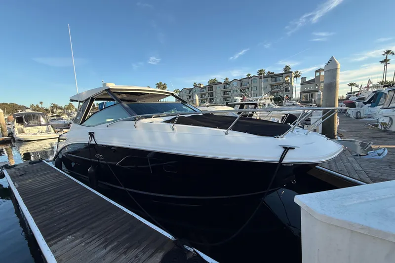 Slide: The Image of 2019 Sea Ray 320 Sundancer docked at marina with clear sky backdrop. - 21