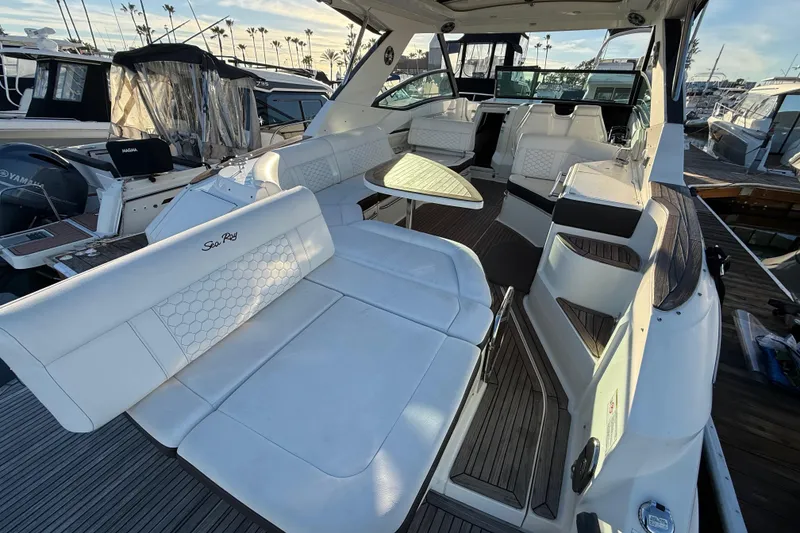 Slide: The Image of 2019 Sea Ray 320 Sundancer yacht interior with white seating and wooden flooring. - 4