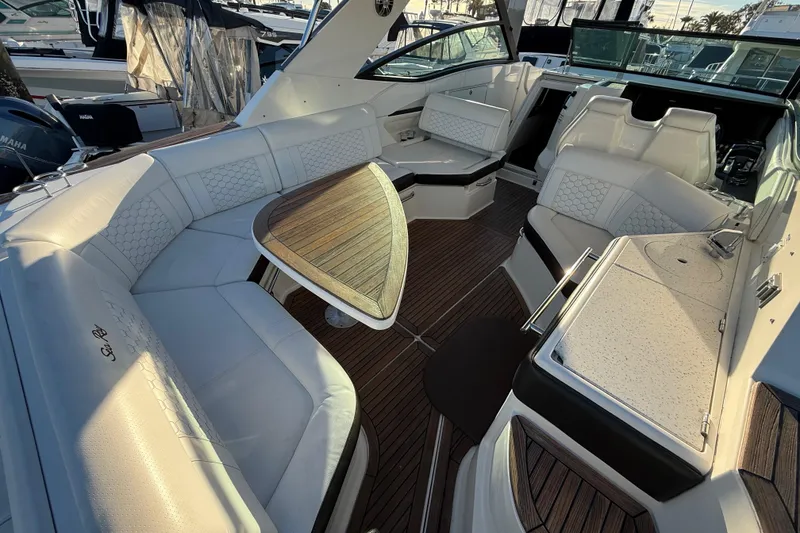 Slide: The Image of Luxurious 2019 Sea Ray 320 Sundancer boat interior with elegant seating and wooden table. - 5