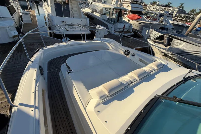 Slide: The Image of 2019 Sea Ray 320 Sundancer yacht docked at marina, featuring spacious deck seating. - 7