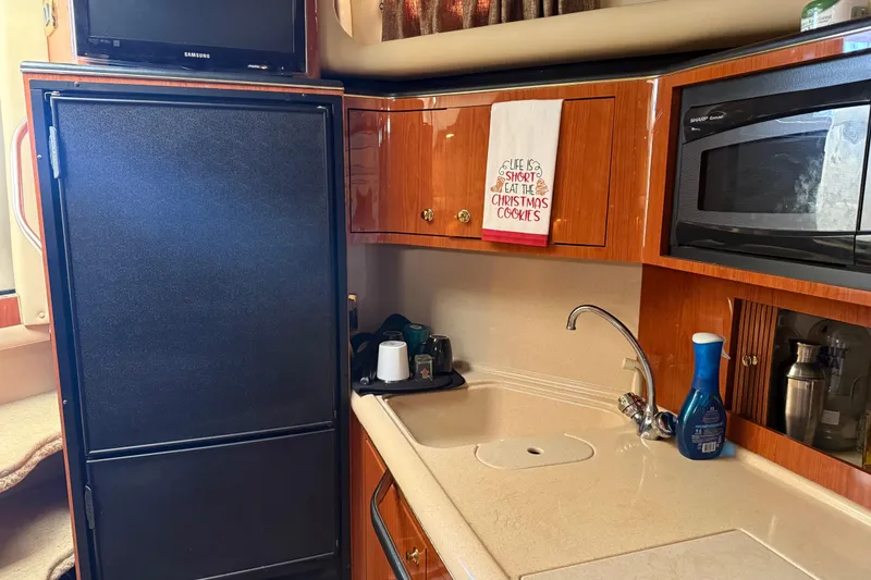 Slide: The Image of 2001 Sea Ray 380 Sundancer kitchen with fridge, microwave, and sink. - 12