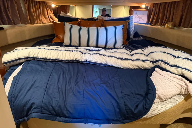 Slide: The Image of Cozy cabin interior of 2001 Sea Ray 380 Sundancer with plush bedding and pillows. - 14