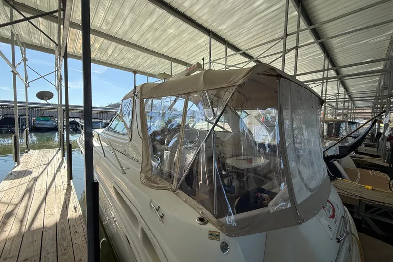 Slide: The Image of 2001 Sea Ray 380 Sundancer docked under a covered marina, side view. - 2