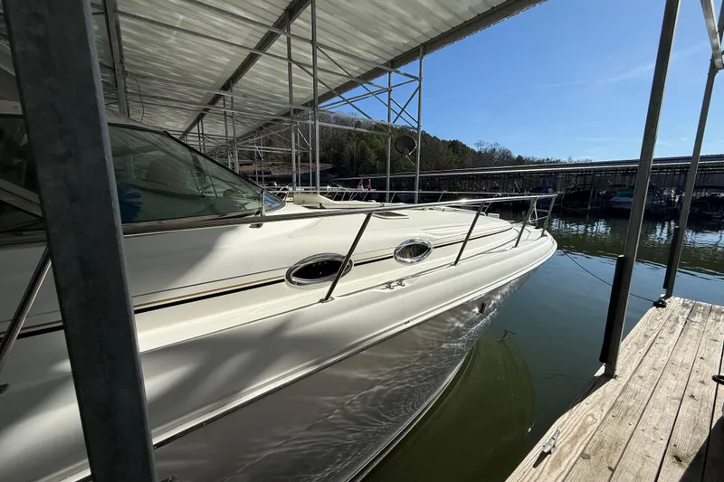 Slide: The Image of 2001 Sea Ray 380 Sundancer docked under a covered marina, reflecting on calm water. - 6