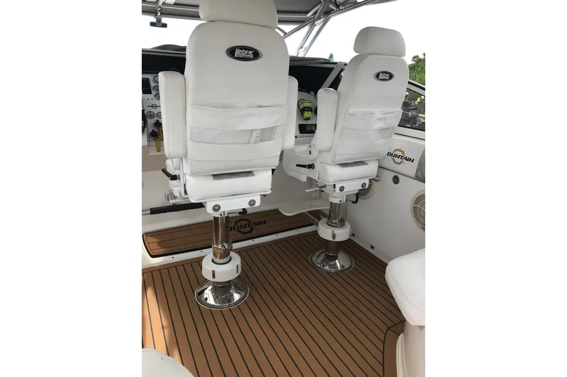 Slide: The Image of 2007 Fountain 38 Sportfish Cruiser OB cockpit with white seats and teak flooring. - 10