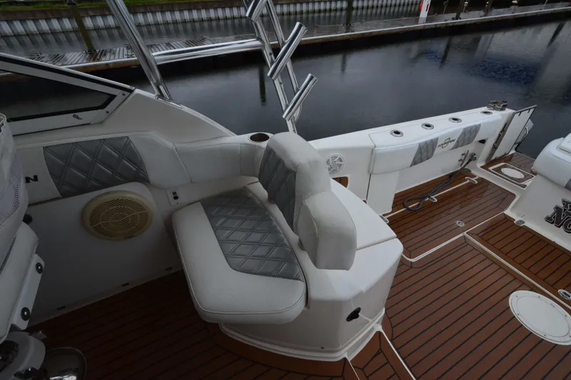 Slide: The Image of 2007 Fountain 38 Sportfish Cruiser OB with cushioned seating and teak deck at a marina. - 13