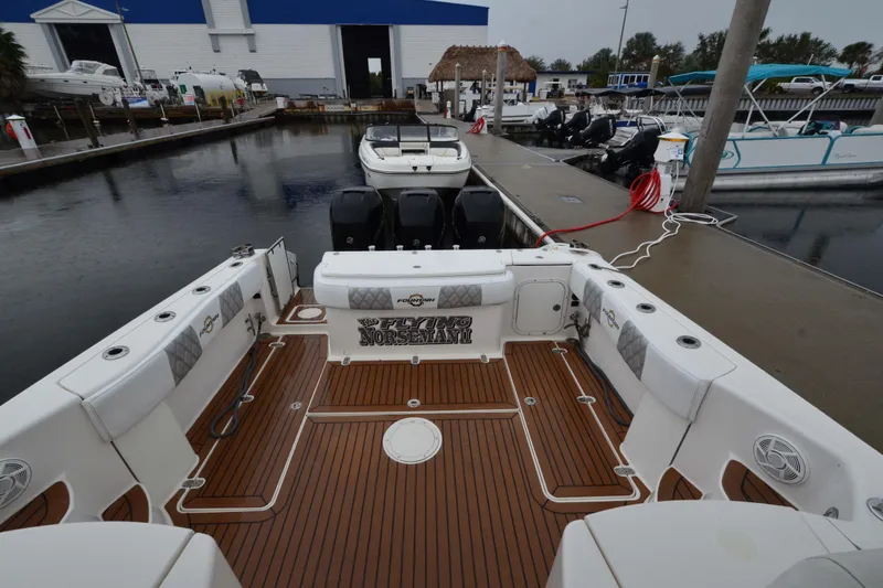 Slide: The Image of 2007 Fountain 38 Sportfish Cruiser OB at marina, featuring spacious deck and outboard engines. - 15