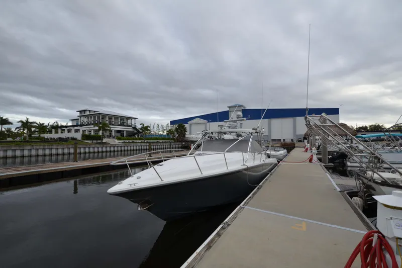 Slide: The Image of 2007 Fountain 38 Sportfish Cruiser OB docked at marina under cloudy sky. - 3