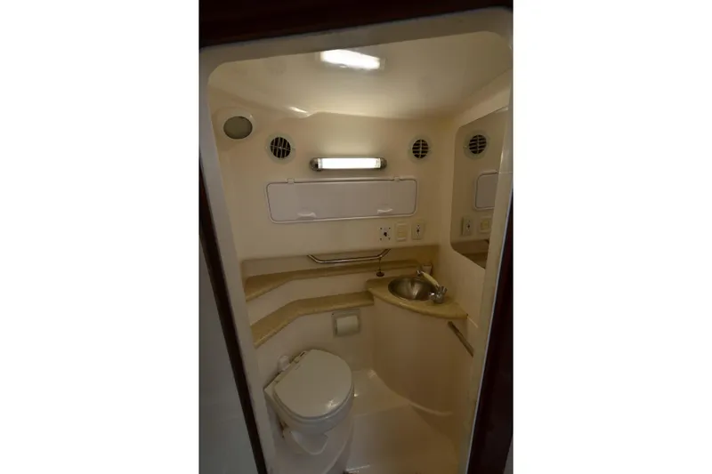 Slide: The Image of 2007 Fountain 38 Sportfish Cruiser OB bathroom with toilet, sink, and storage. - 32