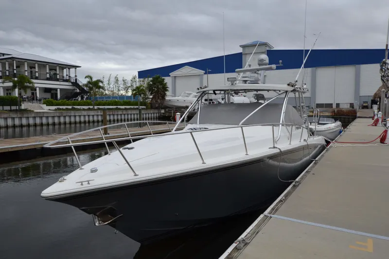 Slide: The Image of 2007 Fountain 38 Sportfish Cruiser OB docked at marina under cloudy sky. - 4
