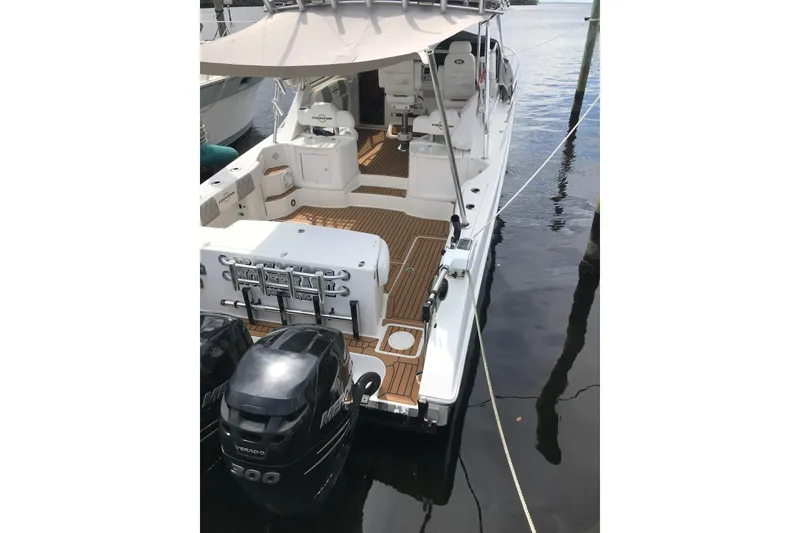 Slide: The Image of 2007 Fountain 38 Sportfish Cruiser OB docked, featuring spacious deck and twin outboard engines. - 6