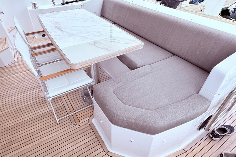 Slide: The Image of Luxurious seating area on 2020 Azimut 60 yacht with marble table and cushioned bench. - 1