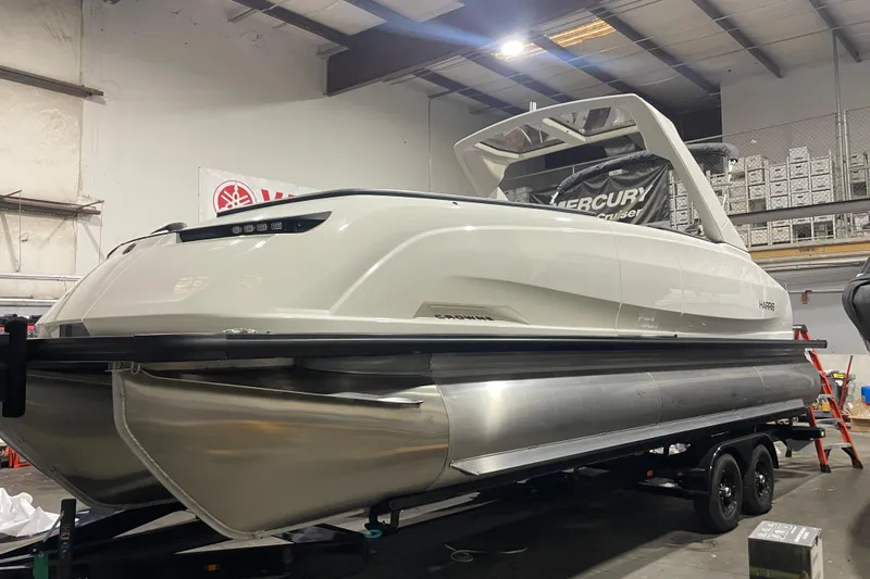 The Image of 2026 Harris Crowne 250 pontoon boat in a showroom, featuring sleek design and modern amenities. - 0