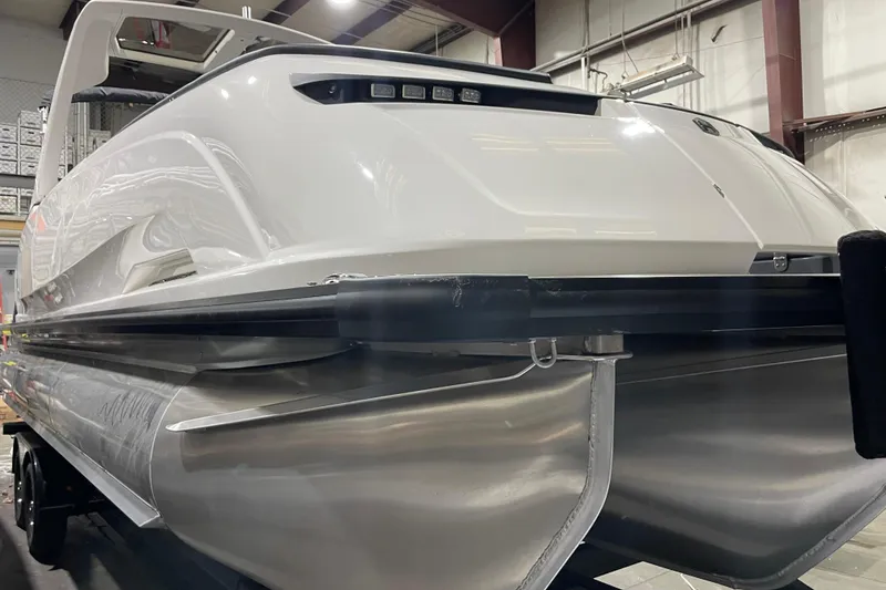 Slide: The Image of 2026 Harris Crowne 250 pontoon boat in a showroom, showcasing sleek design and modern features. - 1