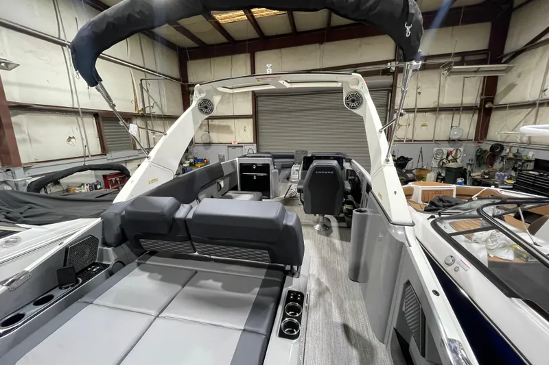 Slide: The Image of 2026 Harris Crowne 250 boat interior with modern seating and sleek design in a warehouse. - 14